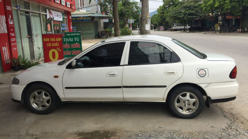 Mazda 323 2000 - Cần bán xe Mazda 323 sản xuất 2000, màu trắng